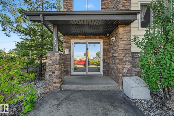 Close-up of the building entrance with glass doors and stone pillar. - #202 11935 106st Nw, Edmonton