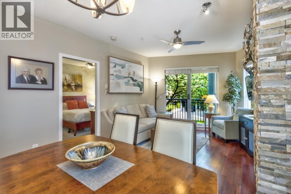 View from dining area into living room and through doorway to bedroom. - 202 1928 Nelson Street, Vancouver