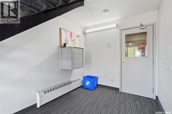 Empty room with light grey walls, laminate flooring, and a doorway to a closet. - 202 345 Kingsmere Boulevard, Saskatoon