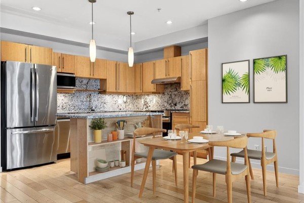 Close-up of kitchen with modern finishes, including granite countertops and pendant lighting. - 202 6591 Lincroft Rd, Sooke