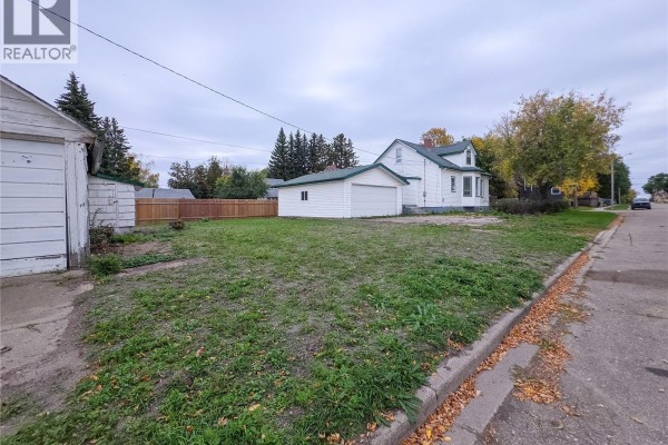 View of property from street showing house, detached garage, storage shed, and street. - 202 6th Avenue E, Melville
