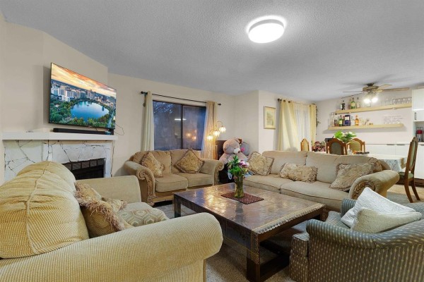 Bedroom with a queen-size bed, large closet, and a wooden dresser. - 202 7064 133b Street, Surrey
