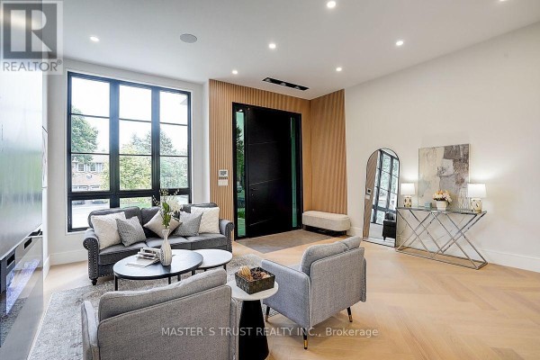 Front entrance with a large black door, wood paneling, a console table, and an arched mirror. - 202 Carlton Road, Markham