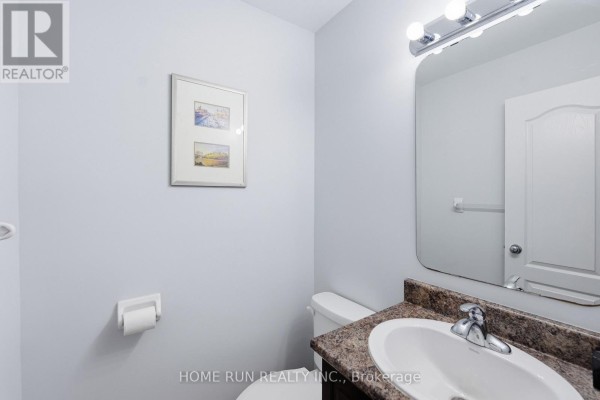 Powder room with a toilet, vanity, and a large mirror above the sink. - 202 Maxwell Bridge Road, Ottawa