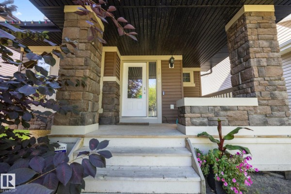 View of the covered porch with two chairs and a small table next to the white front door. - 2020 Glenridding Gate Ga Sw, Edmonton