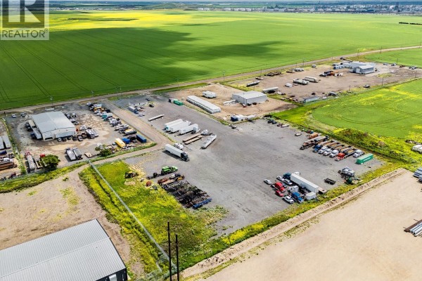 Aerial view of lot with outlined boundaries, showing parked vehicles and surrounding agricultural land. - 2020 Winnipeg Street N, Sherwood Rm No  159