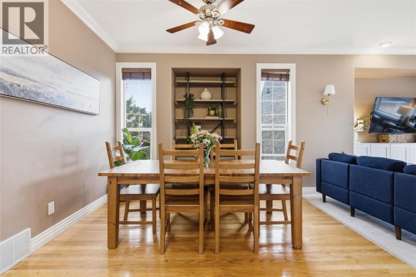 Dining room with a wooden table and chairs, adjacent to a living area. - 2025 Panorama Court, Kamloops