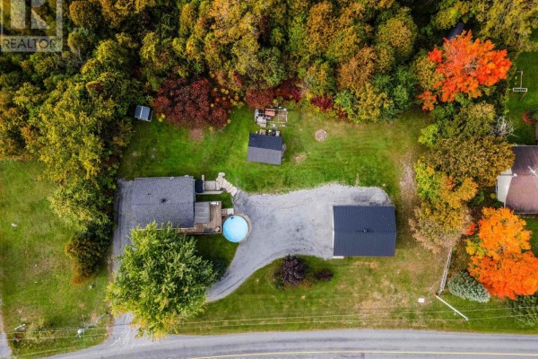 Aerial view of property with house, garage, shed, small pool, and surrounding trees. - 20251 Kenyon Conc Rd 1 Concession, North Glengarry