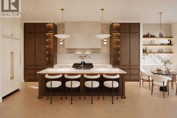 Luxurious kitchen with a large island, dark wood cabinets, and marble countertops. - 2027 25 Street Sw, Calgary