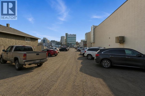 Gravel parking lot with several cars and a pickup truck. - 203, 5233 49 Avenue, Red Deer