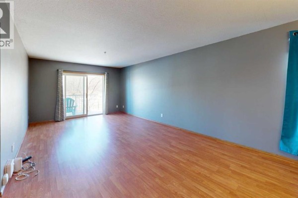 U-shaped kitchen with white cabinets, tan counters, and a white refrigerator. - 203, 9508 99 Street, Lac La Biche