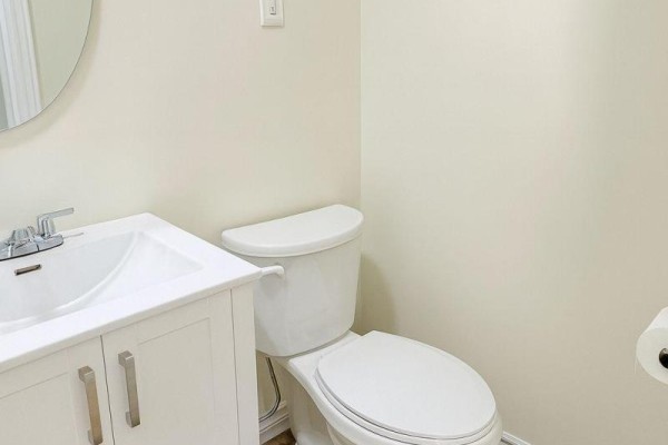 Bathroom with a white vanity, sink, faucet, toilet, and toilet paper holder. - 203 - 198-200 Queen Street W, Toronto