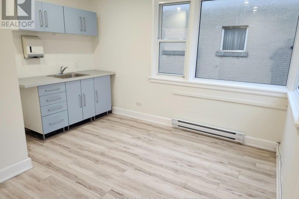 Interior room with kitchenette, gray cabinets, and large window - 203 - 357 Main Street E, Hamilton