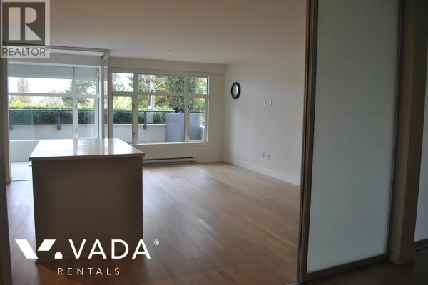 Living room with hardwood floors, large windows, and access to a balcony. - 203 4355 W 10th Avenue, Vancouver