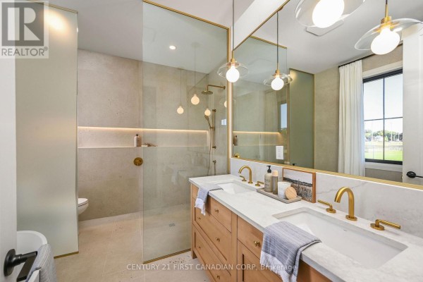Luxurious bathroom with a double vanity, walk-in shower, and contemporary fixtures. - 203 Foxborough Place, Thames Centre