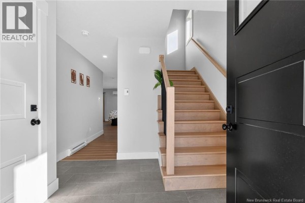 Entryway featuring a staircase, grey walls, and a tiled floor. - 203 Teaberry Avenue, Moncton