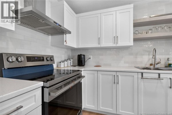 Kitchen corner showing stainless steel appliances and white tile backsplash. - 203 Teaberry Avenue, Moncton