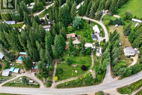Aerial view of a rural property with several homes, trees, and swimming pools. - 2030 Solsqua-sicamous Road, Sicamous
