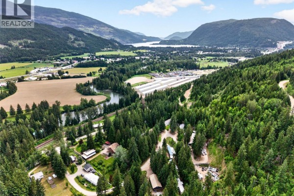Panoramic aerial view of a valley with a lake, trees, and scattered buildings. - 2030 Solsqua-sicamous Road, Sicamous