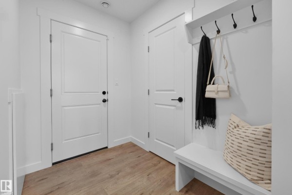 Kitchen with stainless steel appliances, wood cabinetry, and quartz countertops. - 2032 Marquis Wy Ne, Edmonton