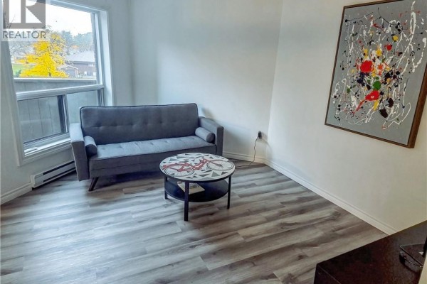 Living room with gray sofa, coffee table, and abstract art on the wall. - 2035 South Millway End Unit# 62, Mississauga