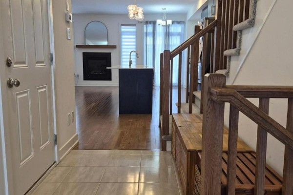 View of the hallway with stairs, kitchen in the background, and natural light - 2037 Allegrini Terrace, Ottawa