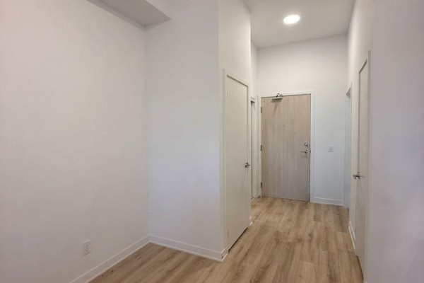 View of apartment interior hallway with light wood flooring and multiple doors. - 204 - 181 Sheppard Avenue E, Toronto