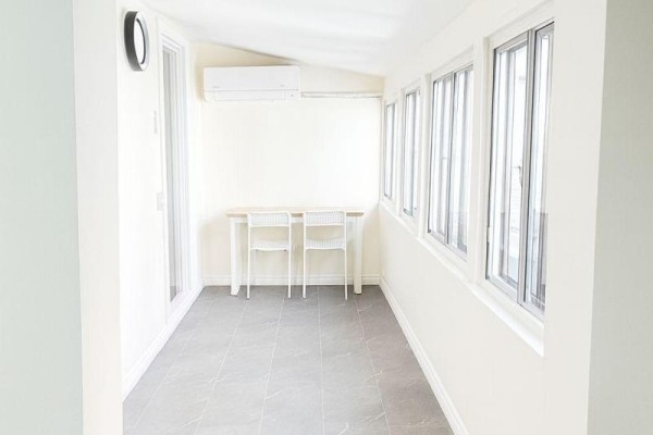 Sunroom with a table, two chairs, and a wall of windows. - 204 - 198-200 Queen Street W, Toronto