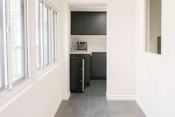 Hallway with a table, chairs, and a view into a kitchenette. - 204 - 198-200 Queen Street W, Toronto