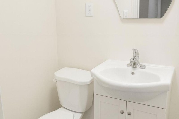Bathroom with a white toilet and a white vanity with a sink. - 204 - 198-200 Queen Street W, Toronto