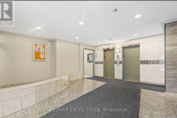 Apartment building lobby with marble tile floors, dark carpet, and elevators. - 204 - 2255 Weston Road, Toronto