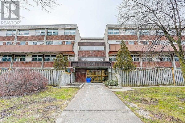 Exterior of a brick apartment building with multiple windows and balconies under a cloudy sky. - 204 - 3765 Sheppard Avenue, Toronto