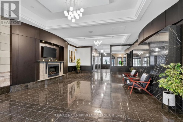 Spacious lobby with dark marble floors, fireplace, modern chandelier, and seating. - 204 - 435 Albert Street, Ottawa