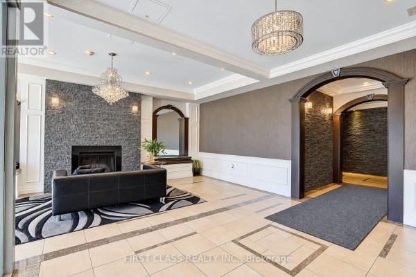 Apartment building lobby with a fireplace, archways, textured walls, and crystal chandeliers. - 204 - 777 Steeles Avenue W, Toronto