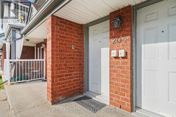 Close-up view of townhouse front door number 204 with red brick exterior. - 204 - 88 Lafleche Boulevard, Casselman