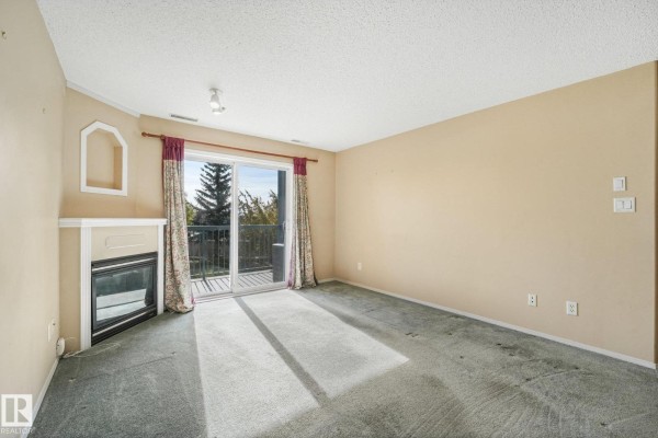 Kitchen and dining area with light wood cabinets, glass table, and double doors. - #204 16303 95 St Nw, Edmonton