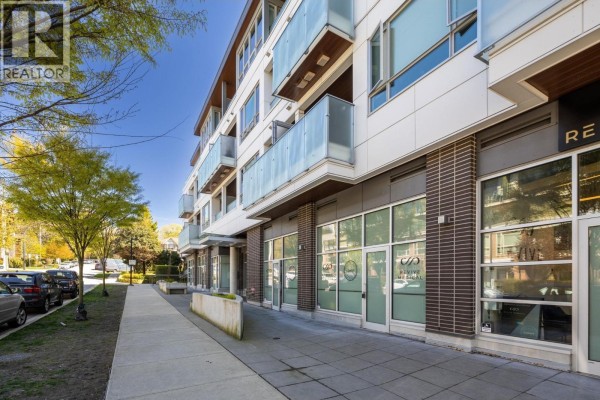 Sidewalk view of ground floor commercial spaces with large glass windows. - 204 711 W 14th Street, North Vancouver