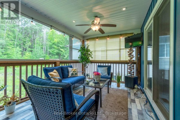 Covered porch with blue furniture, ceiling fan, TV - 204 Golf Course Road Wasaga Beach