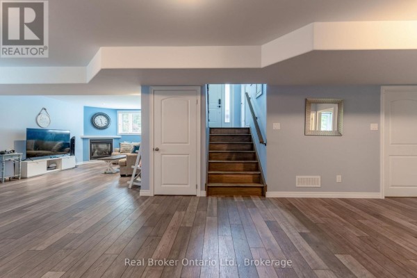 Finished basement living room with fireplace and wood floors - 204 Golf Course Road Wasaga Beach