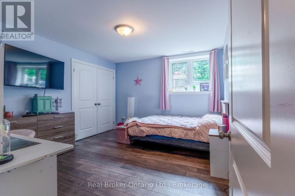 Bedroom with TV, dresser, bed, and window - 204 Golf Course Road Wasaga Beach