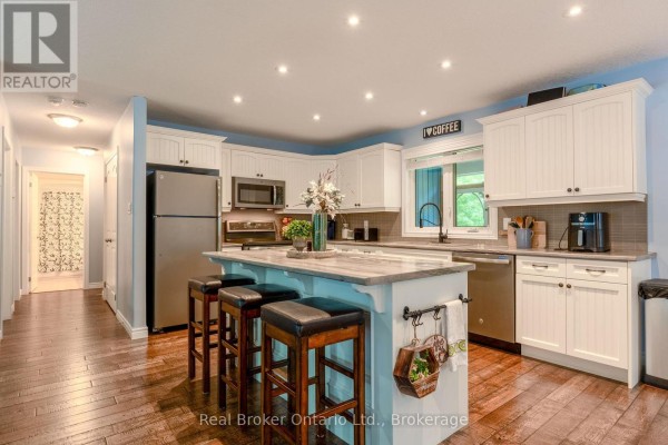 Renovated kitchen with island, stainless steel appliances, and hardwood floors - 204 Golf Course Road Wasaga Beach