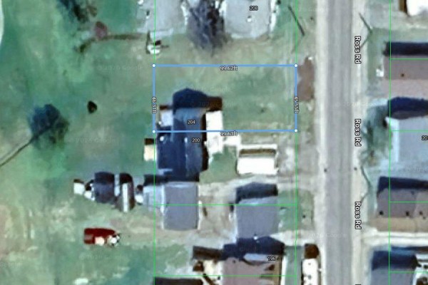 Aerial view showing the property boundaries of 204 Ross Road, an undeveloped lot with adjacent buildings. - 204 Ross Road, Smooth Rock Falls