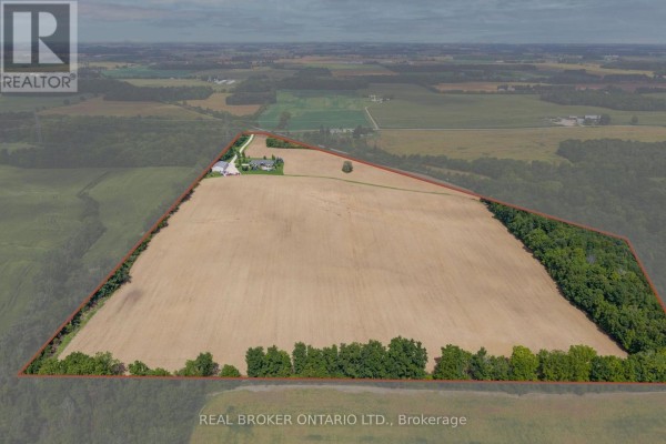 Drone shot showing a vast farm field with a house and trees on one side, property outlined in red. - 204364 Keswick Road, South West Oxford