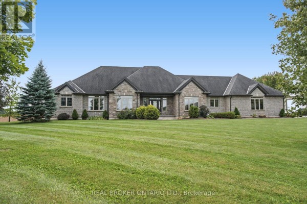 Front exterior of a large, single-story brick house with manicured green lawn and trees. - 204364 Keswick Road, South West Oxford