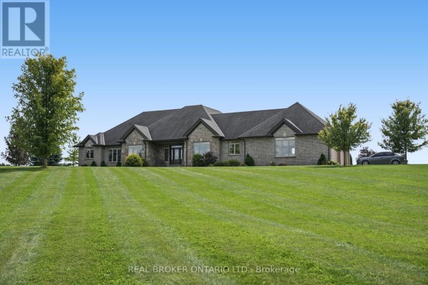 View of the front facade of a sprawling brick ranch home with stone accents and a large yard. - 204364 Keswick Road, South West Oxford