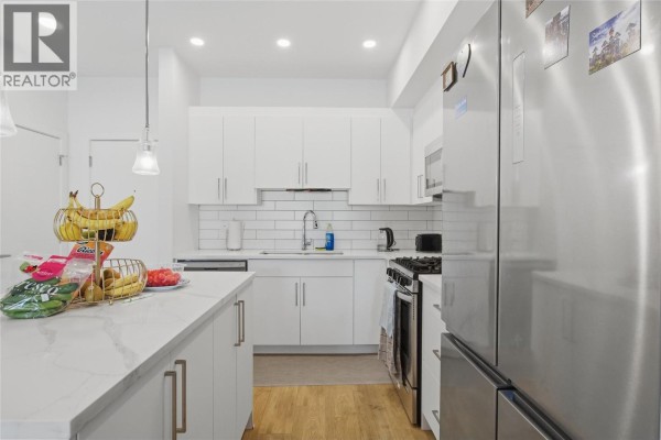 A white kitchen island with marble countertop displays fruit and snacks. - 2046 Robson Place Unit# 216, Kamloops