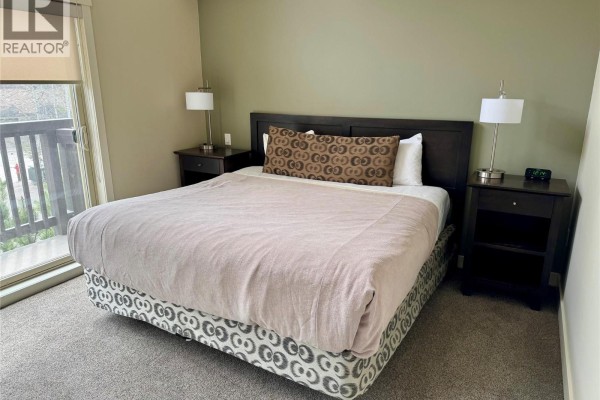 Kitchen with island, dark wood stools, and overhead pendant lighting. - 2049 Summit Drive Unit# 225c, Panorama Mountain