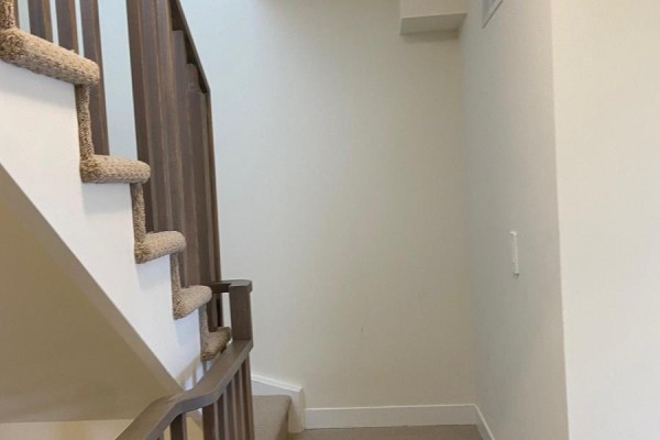 Carpeted stairs with dark wood railing leading to upper level. - 205 - 1695 Dersan Street, Pickering