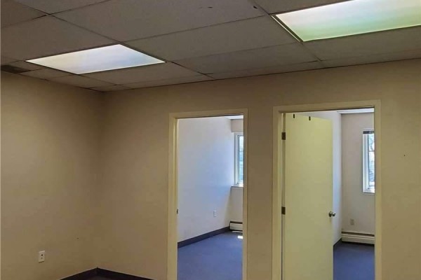 Empty office space with grey carpet and two doorways. - 205 - 35 The Links Road, Toronto