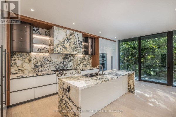 Modern kitchen with marble countertops, island, white cabinetry, and stainless steel appliances. - 205 - 7 Dale Avenue, Toronto